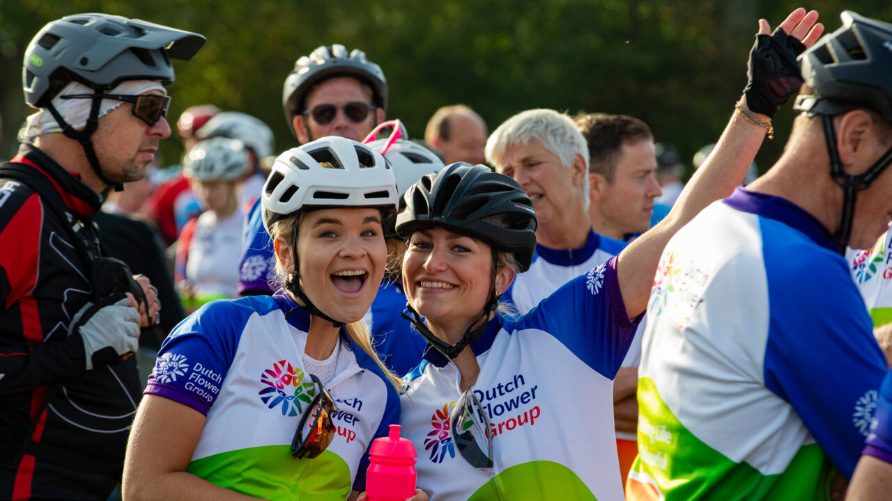 Two smiling DFG participants wearing cycling jerseys and helmets during Ride for the Roses 2026.