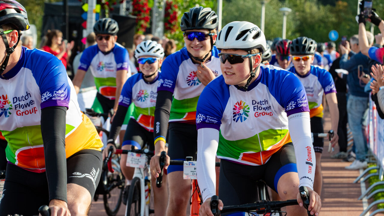 DFG cyclists setting off at the start of Ride for the Roses 2026, cheered on by spectators.