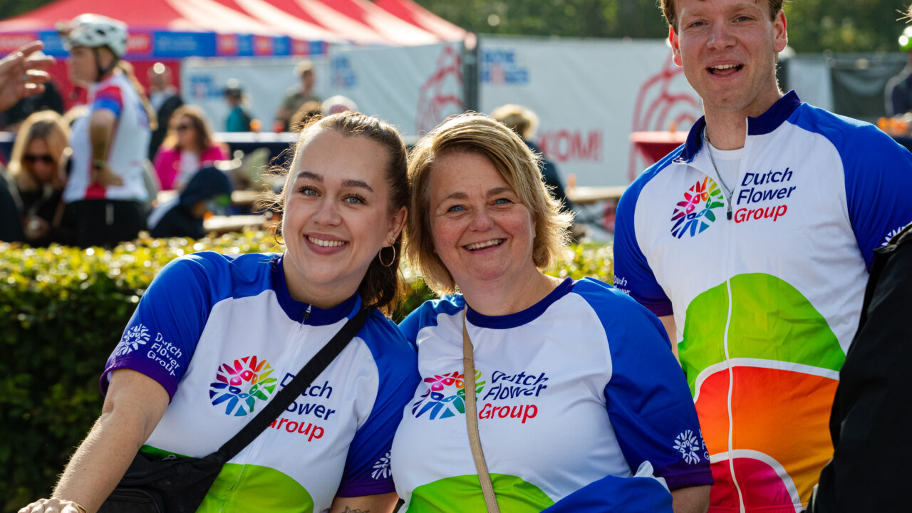 Drie lachende deelnemers in DFG-shirts tijdens Ride for the Roses 2026.